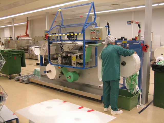 Industrial manufacturing line with material rollers in a workshop